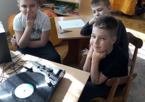 Chłopcy w skupieniu słuchają ścieżki dźwiękowej bajki O Sierotce Marysi z płyty analogowej